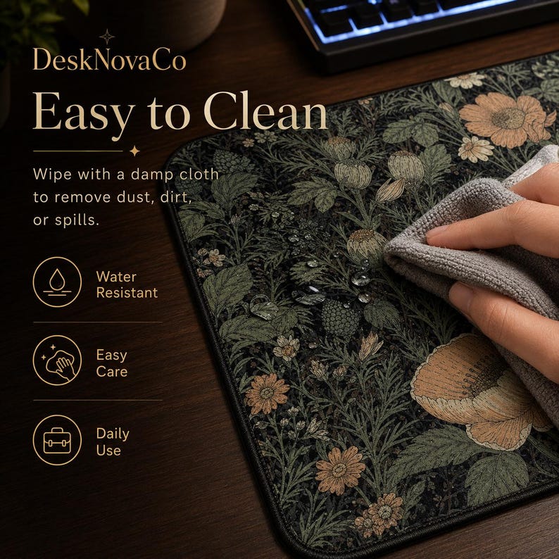 Puede incluir: Alfombrilla de escritorio con estampado floral negro y verde con el texto "Easy to Clean". La alfombrilla se limpia con un pa&ntilde;o gris. La alfombrilla es resistente al agua y f&aacute;cil de cuidar. La alfombrilla est&aacute; dise&ntilde;ada para el uso diario.