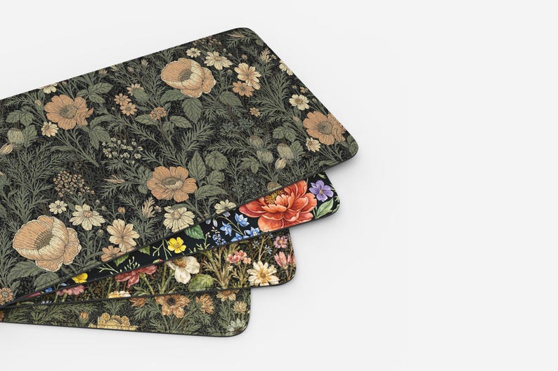 Puede incluir: Tres alfombrillas de rat&oacute;n rectangulares con dise&ntilde;os florales. La alfombrilla superior tiene un fondo oscuro con flores de color beige y verde. La alfombrilla del medio tiene un fondo negro con una gran flor roja. La alfombrilla inferior tiene un fondo oscuro con flores amarillas y beige.
