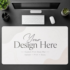 Puede incluir: Una alfombrilla de escritorio rectangular con un fondo color crema y formas beige abstractas. La alfombrilla presenta el texto "Your Design Here" en una fuente elegante, junto con las frases "Custom Print Desk Mat - Upload • Print • Enjoy."