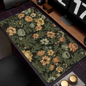 Puede incluir: Alfombrilla de escritorio rectangular con un estampado floral de flores amarillas, naranjas y verdes sobre un fondo verde oscuro. La alfombrilla tiene un dise&ntilde;o detallado con una est&eacute;tica vintage, adecuada para una oficina en casa o un espacio de trabajo.