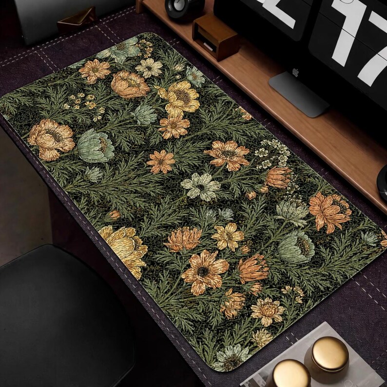 Puede incluir: Alfombrilla de escritorio rectangular con un estampado floral de flores amarillas, naranjas y verdes sobre un fondo verde oscuro. La alfombrilla tiene un dise&ntilde;o detallado con una est&eacute;tica vintage, adecuada para una oficina en casa o un espacio de trabajo.