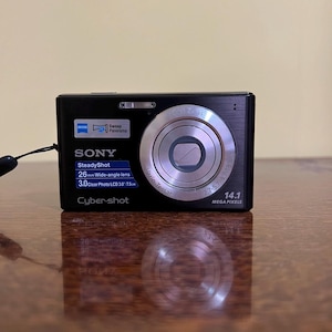 May include: A handmade, wooden cutting board with a natural finish. The board features a live edge on one side and a smooth, rectangular shape. It is approximately 18 inches long and 12 inches wide.