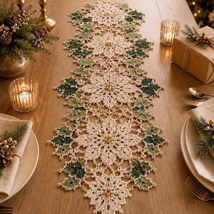 Peut inclure: Un chemin de table en crochet long et rectangulaire présentant un motif répétitif de fleurs de poinsettia blanches et de feuilles de houx vert foncé. Le design est agrémenté de petites perles dorées au centre de chaque fleur et sur la bordure.