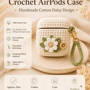 May include: A cream-colored crochet AirPods case featuring a white and yellow daisy appliqué with sage green leaves and a wooden button closure. It includes a detachable sage green wrist strap and measures 7 cm W x 5 cm H x 2.5 cm D.