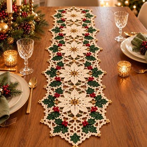 Può includere: Un runner da tavola rettangolare all'uncinetto con un motivo ripetuto di fiori di stella di Natale bianchi con centri di perline dorate, intervallati da foglie di agrifoglio verde scuro e grappoli di piccole bacche rosse, con bordo in pizzo.