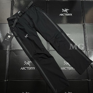Puede incluir: Pantalones negros para exteriores con cintur&oacute;n incorporado y rayas grises oscuras en los laterales. Los pantalones tienen cierre de cremallera y el logotipo de Arc'teryx es visible. Los pantalones se muestran sobre una superficie de cajas negras.