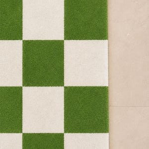 May include: A rectangular area rug featuring a high-pile texture with a repeating checkerboard pattern of alternating grass green and off-white squares. The rug has clean, straight edges and a consistent, dense tufted surface throughout the design.