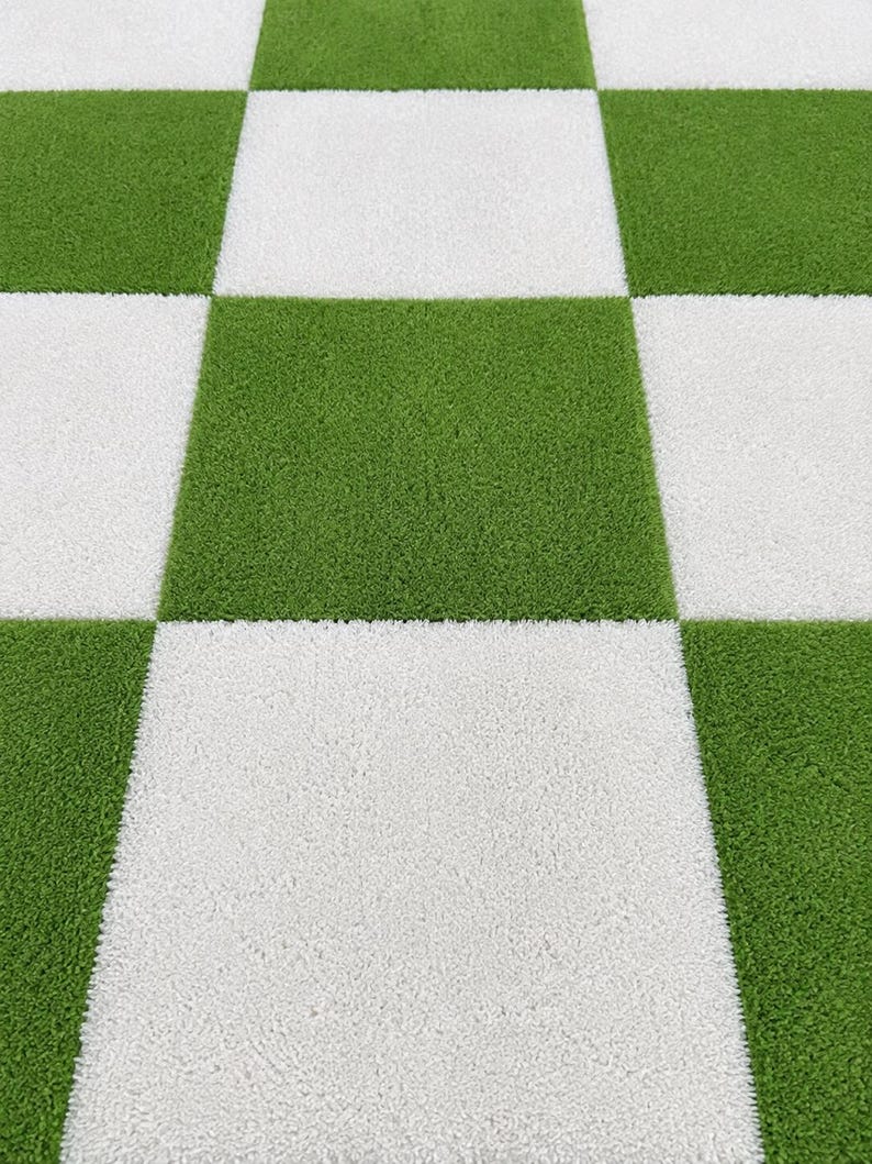 May include: A square-patterned rug featuring a repeating checkerboard design of alternating bright green and white textured squares. The surface has a short, dense pile that creates a uniform, grid-like appearance across the entire floor covering.