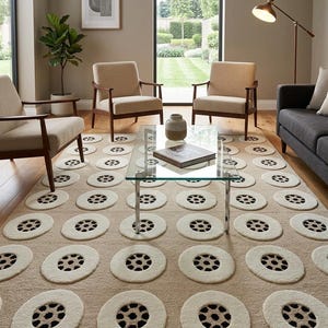 May include: Beige area rug with a repeating pattern of large, off-white circles with black centers. The rug is in a living room setting with mid-century modern furniture and a glass coffee table.