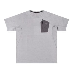 May include: A light gray short-sleeved shirt with a crew neck and a dark gray pocket on the chest. The pocket has a zipper and a small logo. The shirt has a relaxed fit and is made of a lightweight material.