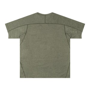 May include: Olive green t-shirt with a crew neck and short sleeves. The shirt has a textured appearance and features stitching details along the shoulders and sleeves. The back of the shirt is visible, showcasing the design.