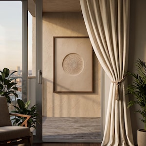 May include: A rectangular wall art piece featuring a central circular indentation filled with a dense pattern of small dark dots, enclosed in a thin brown wooden frame. The artwork is mounted on a textured beige wall visible through a glass door.