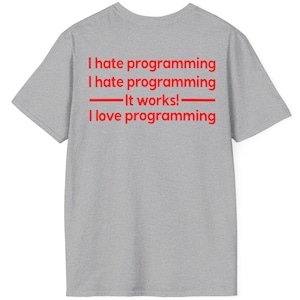 May include: A heather gray t-shirt with red text that reads "I hate programming" twice, followed by "-It works!-" and "I love programming". The shirt is a casual wear item.