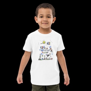 May include: White t-shirt with a colourful doodle design and the words "Street Special". The graphic includes a sun, buildings, and other whimsical elements. The shirt is worn by a young child.