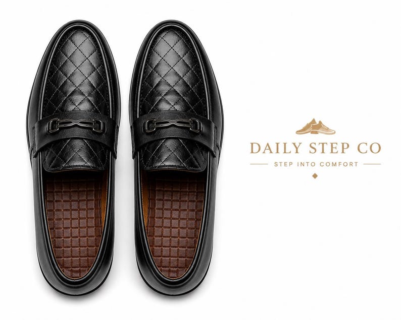 May include: A pair of black loafers featuring a quilted diamond pattern on the upper, a black metal bit detail across the vamp, and a brown grid-textured insole. The text DAILY STEP CO STEP INTO COMFORT is displayed to the right of the shoes.