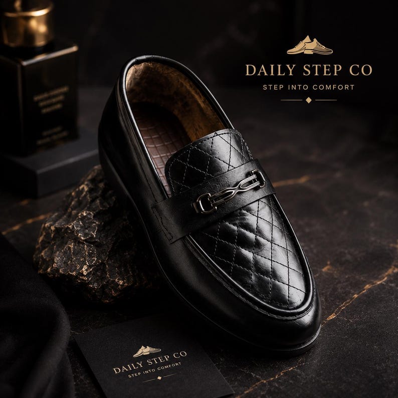 May include: A black loafer featuring a quilted diamond pattern on the vamp and a metallic bit ornament across the bridge. The shoe includes the text DAILY STEP CO STEP INTO COMFORT. The interior lining has a textured brown finish.