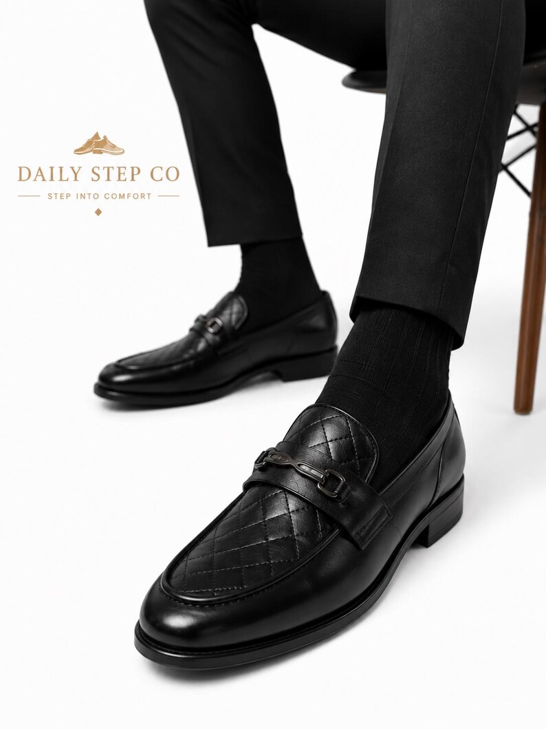 May include: Black leather loafers featuring a quilted diamond pattern on the vamp, a dark metal horsebit detail across the bridge, and a low heel. The text DAILY STEP CO STEP INTO COMFORT is visible in the upper left corner of the image.