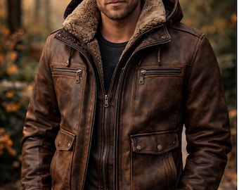 May include: A brown leather jacket featuring a detachable hood with a tan faux fur lining, a full-length front zipper, two chest pockets with zippers, two lower flap pockets with snap buttons, and dark brown ribbed cuffs at the sleeves and waist.