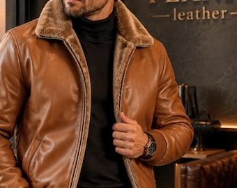 May include: A tan leather bomber jacket featuring a plush brown faux fur collar and interior lining, a full-length front zipper, and ribbed knit cuffs. The jacket is worn over a black turtleneck sweater and dark trousers, showcasing a classic design.