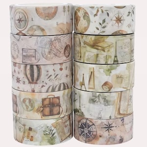 Puede incluir: Una pila de diez rollos de cinta adhesiva decorativa con diversas ilustraciones de tem&aacute;tica viajera. Los dise&ntilde;os incluyen mapas antiguos, br&uacute;julas, globos aerost&aacute;ticos, maletas, libros abiertos, sellos postales y la Torre Eiffel en tonos tierra.