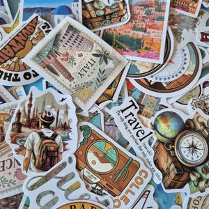 Puede incluir: Una colecci&oacute;n de pegatinas con tem&aacute;tica de viajes que presentan varios lugares emblem&aacute;ticos, mapas y frases relacionadas con los viajes. Las pegatinas muestran ilustraciones de Italia, Par&iacute;s, Santorini y otros destinos, con una mezcla de colores y dise&ntilde;os.