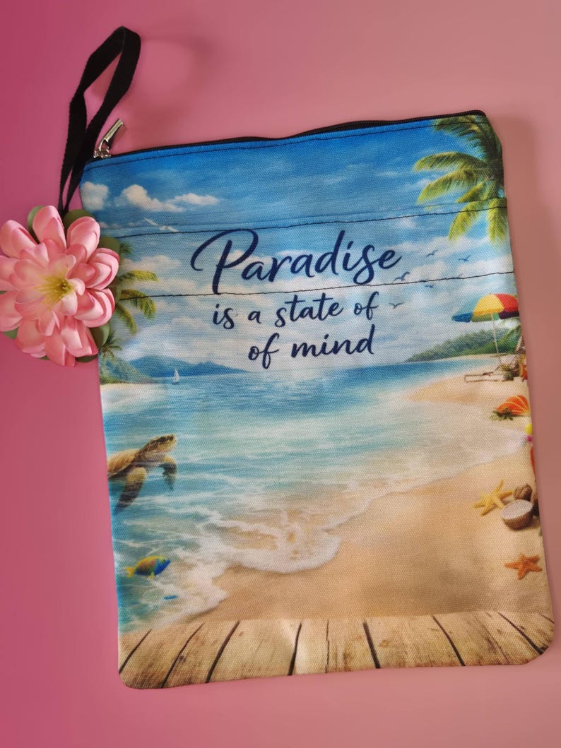 May include: A rectangular beach-themed pouch with a black strap and a pink flower. The pouch features a beach scene with the text "Paradise is a state of mind." The design includes a turtle, palm trees, and a colorful umbrella.