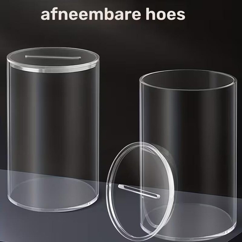 K&ouml;nnte beinhalten: Transparenter zylindrischer Beh&auml;lter aus Acryl mit einem Schlitz im Deckel. Der Deckel ist abnehmbar und der Beh&auml;lter ist transparent, wodurch der Inhalt sichtbar ist. Der Text "afneembare hoes" steht oben.