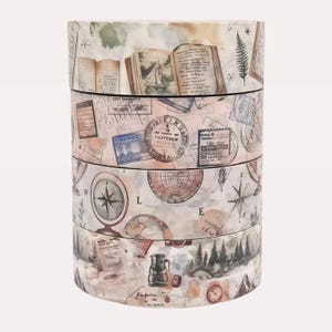 Pu&ograve; includere: Una pila di quattro rotoli di nastro adesivo decorativo con illustrazioni in stile vintage. I disegni includono libri aperti con barche a vela, francobolli, bussole, mappamondi, scrittura a mano, alberi di pino e una caffettiera.