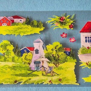 Op de afbeelding: Een decoratieve strook met geschilderde dorpssc&egrave;nes. De sc&egrave;nes omvatten huizen, windmolens en groene landschappen met rode en witte gebouwen. Het kunstwerk is geplaatst tegen een lichtblauwe achtergrond.