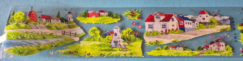 Op de afbeelding: Een decoratieve strook met geschilderde dorpssc&egrave;nes. De sc&egrave;nes omvatten huizen, windmolens en groene landschappen met rode en witte gebouwen. Het kunstwerk is geplaatst tegen een lichtblauwe achtergrond.