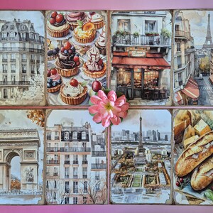 May include: Watercolour artwork depicting Parisian scenes, including buildings, the Eiffel Tower, and a bakery. The artwork also depicts various pastries, bread, and cheese. A pink flower is placed in the centre of the artwork.