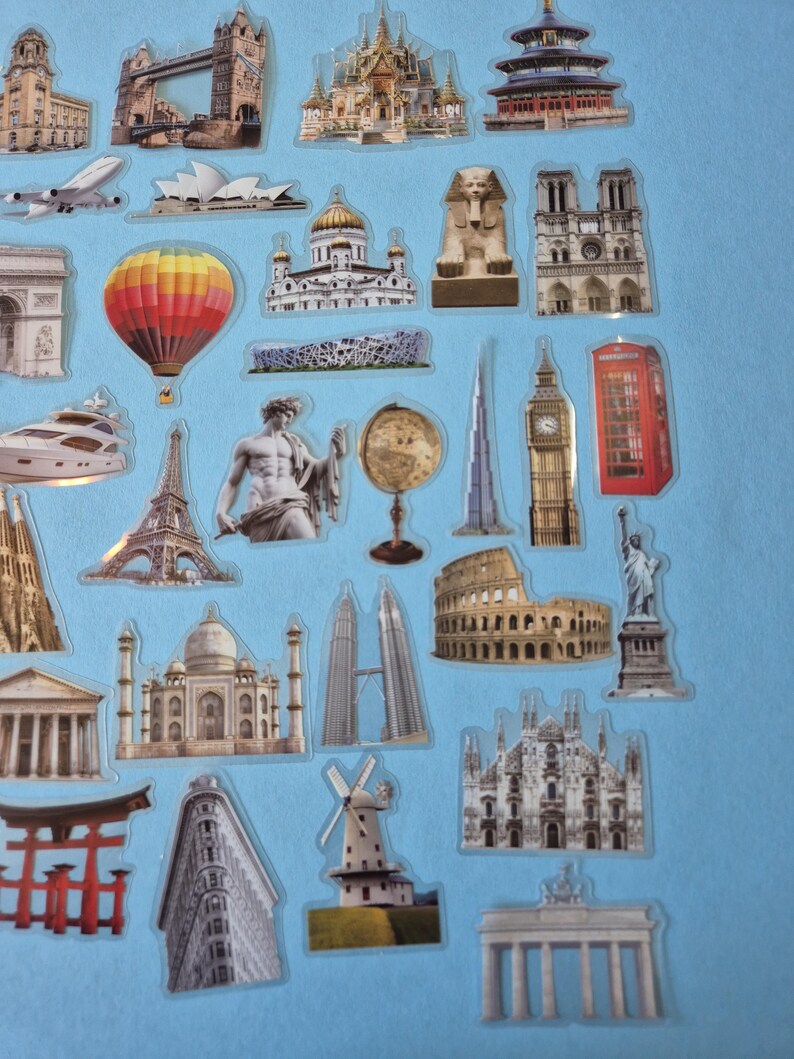 May include: A selection of travel-themed stickers depicting famous landmarks. Includes the Tower Bridge, the Eiffel Tower, Big Ben, the Colosseum, and the Taj Mahal. The stickers are set against a light blue backdrop.