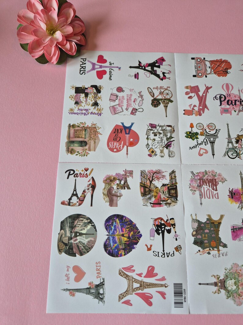 May include: Sheets of Paris-themed stickers with various illustrations, including the Eiffel Tower, hearts, and fashion elements. The stickers feature text like "Paris," "Je t'aime," and "Bonjour," with a pink flower in the corner.