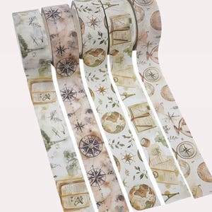 Puede incluir: Cinco rollos de cinta adhesiva decorativa con tem&aacute;tica de viajes vintage. Los dise&ntilde;os incluyen ilustraciones de br&uacute;julas, globos terr&aacute;queos, libros abiertos, hojas bot&aacute;nicas y la Torre Eiffel en tonos marrones, verdes y crema.