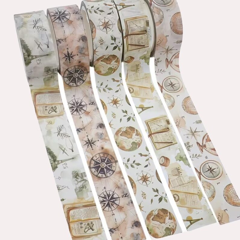 Puede incluir: Cinco rollos de cinta adhesiva decorativa con tem&aacute;tica de viajes vintage. Los dise&ntilde;os incluyen ilustraciones de br&uacute;julas, globos terr&aacute;queos, libros abiertos, hojas bot&aacute;nicas y la Torre Eiffel en tonos marrones, verdes y crema.