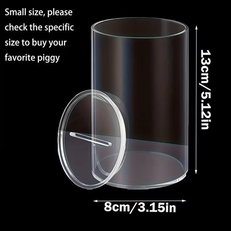 K&ouml;nnte beinhalten: Transparente Spardose aus Acryl mit abnehmbarem Deckel. Die zylindrische Dose ist 13 cm hoch und hat einen Durchmesser von 8 cm. Der Text auf dem Bild lautet: "Small size, please check the specific size to buy your favorite piggy."