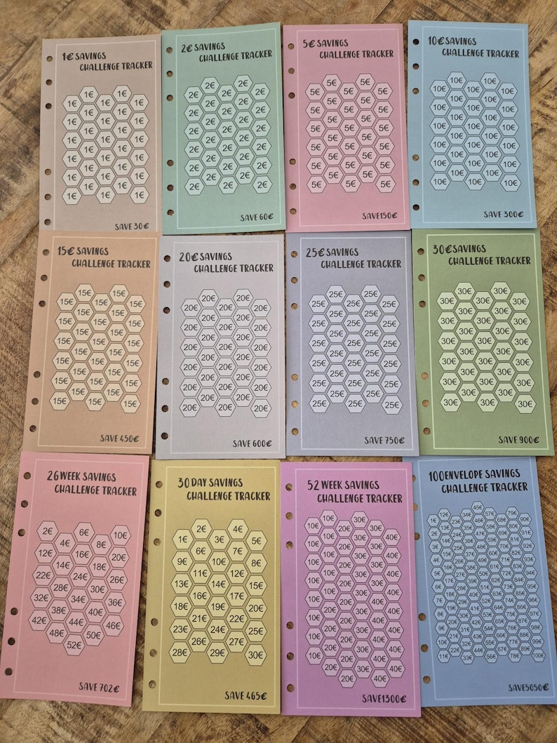 Pode incluir: Um conjunto de rastreadores de desafios de poupan&ccedil;a coloridos. Cada rastreador apresenta um design de favo de mel com valores de 1&euro; a 100&euro;, e o texto "Savings Challenge Tracker". Os rastreadores s&atilde;o de v&aacute;rias cores, com o valor total poupado impresso.