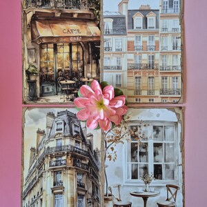 May include: A collage of watercolour paintings depicting Parisian scenes. One shows a cafe with a brown awning and the word "CAFE". Other images include buildings and a cafe table with chairs. A pink flower is placed on top.