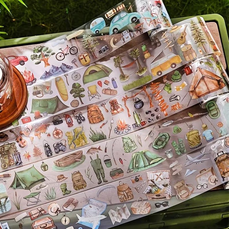 K&ouml;nnte beinhalten: Eine Rolle transparentes Klebeband mit einem sich wiederholenden Aquarellmuster aus Campingausr&uuml;stung, darunter Zelte, Rucks&auml;cke, Kanus, Lagerfeuer, Gitarren, B&auml;ume, Berge, Fahrr&auml;der und verschiedene Reiseaccessoires in erdigen Farbt&ouml;nen.