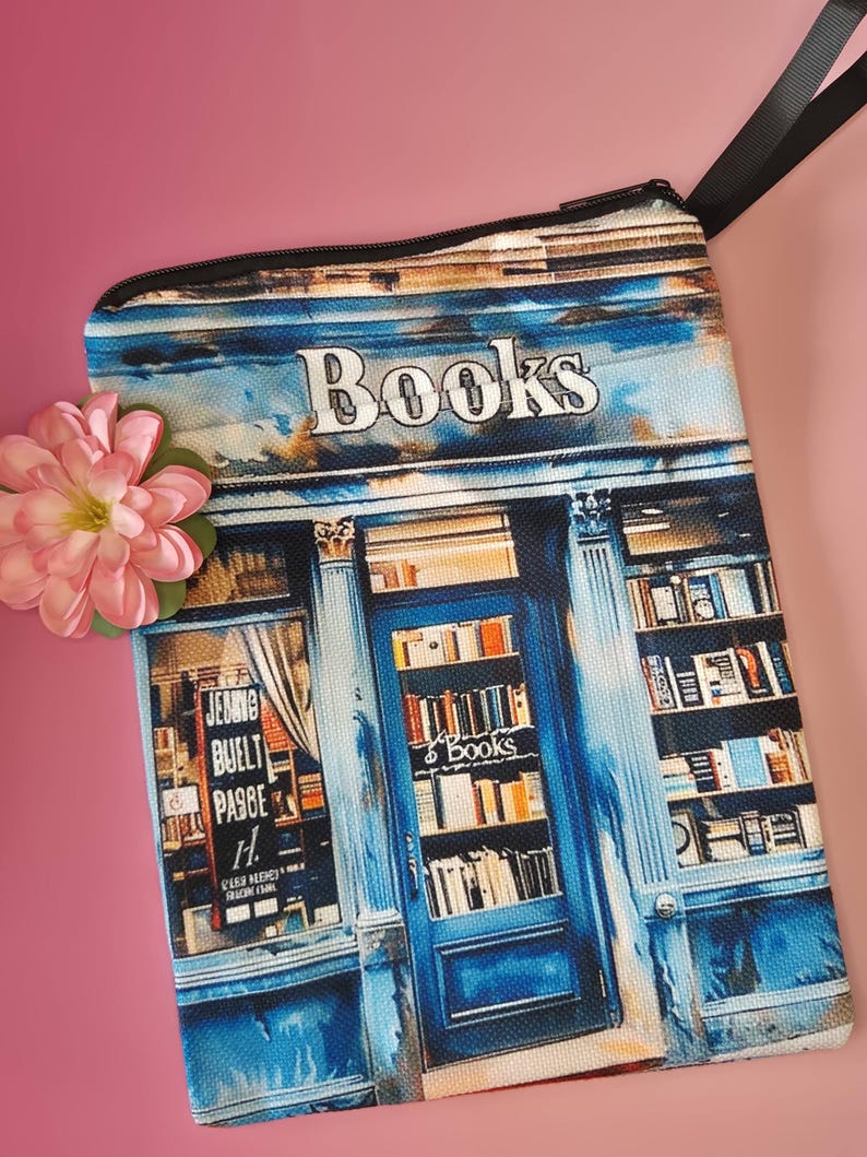 May include: A rectangular, blue and white zippered pouch with a bookstore design. The pouch features the word "Books" at the top and a detailed illustration of a bookstore facade. A pink flower is in the corner.