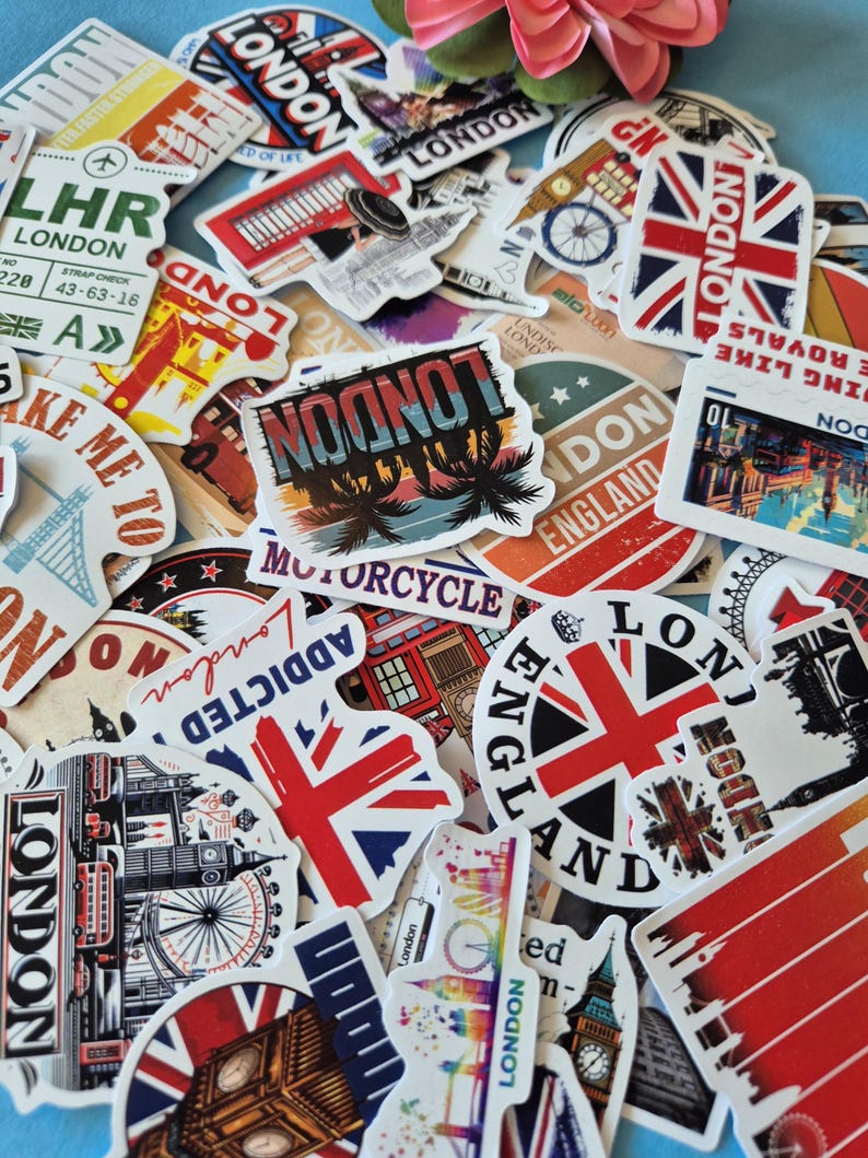 Peut inclure: Un assortiment d'autocollants sur le th&egrave;me de Londres, avec des drapeaux Union Jack, des monuments et des images de voyage. Les autocollants pr&eacute;sentent diverses couleurs et designs, avec des textes comme "London" et "England".