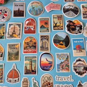 May include: A collection of travel-themed stickers featuring iconic landmarks and destinations. Stickers include the Eiffel Tower, Statue of Liberty, Big Ben, and the Colosseum. The stickers are in various shapes and sizes, with vibrant colors and text.