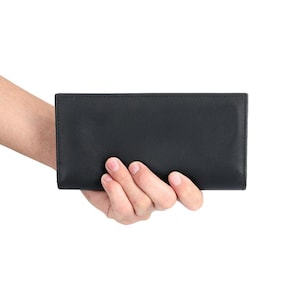 May include: A rectangular black wallet with a smooth, matte finish and clean, straight edges. The wallet features a minimalist design with visible stitching along the top and bottom borders, presenting a slim and functional profile for daily use.
