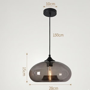 Op de afbeelding: Een moderne hanglamp met een rookglazen kap. De lamp wordt opgehangen aan een zwart snoer, met een totale lengte van 150 cm. De kap is 28 cm breed en 15 cm hoog. De plafondbevestiging heeft een diameter van 10 cm.