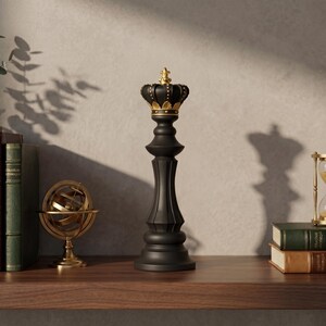 A black chess king figurine with a gold crown is on a wooden shelf next to books, a gold armillary sphere, and an hourglass.