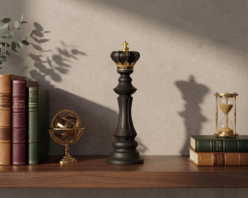 May include: A black chess piece in the shape of a king with a gold crown sits on a wooden shelf. Beside it are books, a golden armillary sphere, and an hourglass. The scene is lit with natural light, casting shadows.