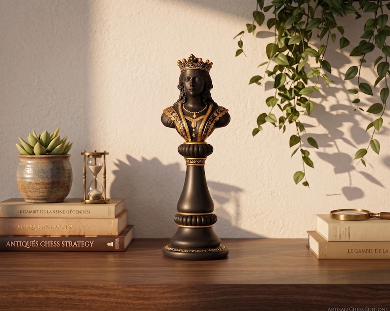 May include: A black and gold chess queen statue with a detailed bust, crown, and ornate collar. The statue is on a wooden surface with books, a succulent plant, and an hourglass. The words "ANTIQU&Eacute;S CHESS STRATEGY" are visible on a book.