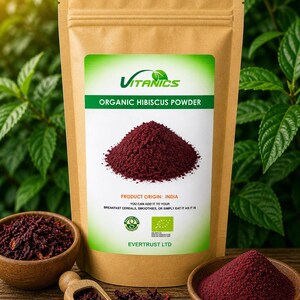 Könnte beinhalten: Eine braune Papiertüte mit Bio-Hibiskuspulver und einem grün-weißen Etikett. Auf dem Etikett steht "Vitanics Organic Hibiscus Powder". Das Bild zeigt auch Schalen mit Hibiskuspulver und getrockneten Hibiskusblüten. Produkt Herkunft: Indien.