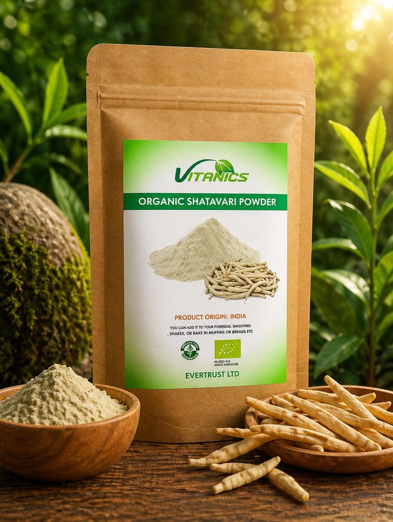 May include: A brown paper bag of Vitancs Organic Shatavari Powder with a green and white label. The label shows a pile of powder and some roots. A wooden bowl of powder and a wooden bowl of roots are in front of the bag.