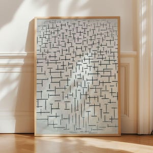May include: Abstract art print in a wooden frame. The artwork features a grid of black lines on a light gray background. The lines vary in length and thickness, creating a dynamic composition. The frame is a light brown color.